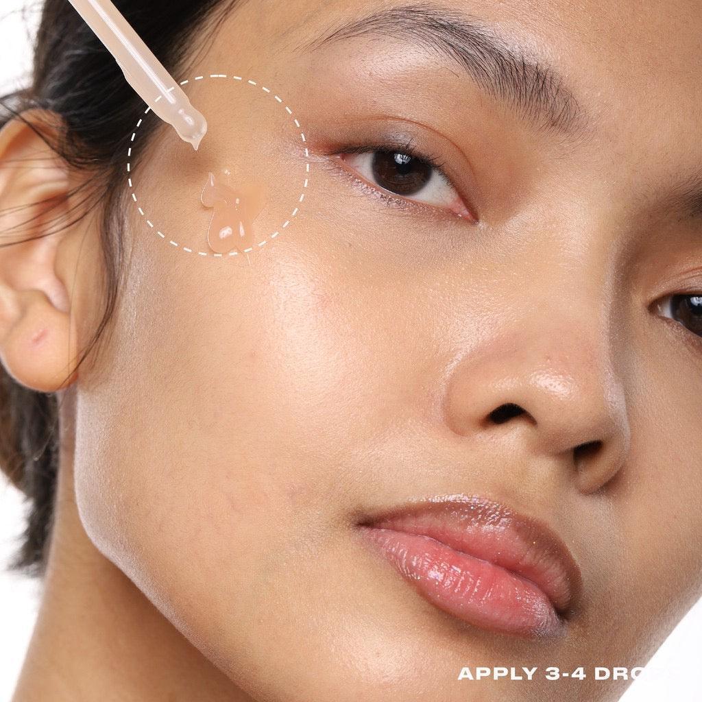 Serum drops applied to cheek with dropper, skincare routine, dewy skin close-up