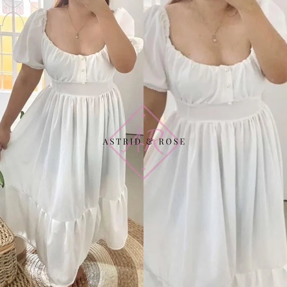 Plus size white puff sleeve dress with gathered waist and button front, worn indoors.