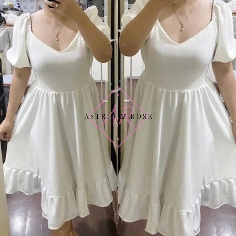 Woman modeling plus size white V-neck dress with puff sleeves and ruffled hem in mirror selfie