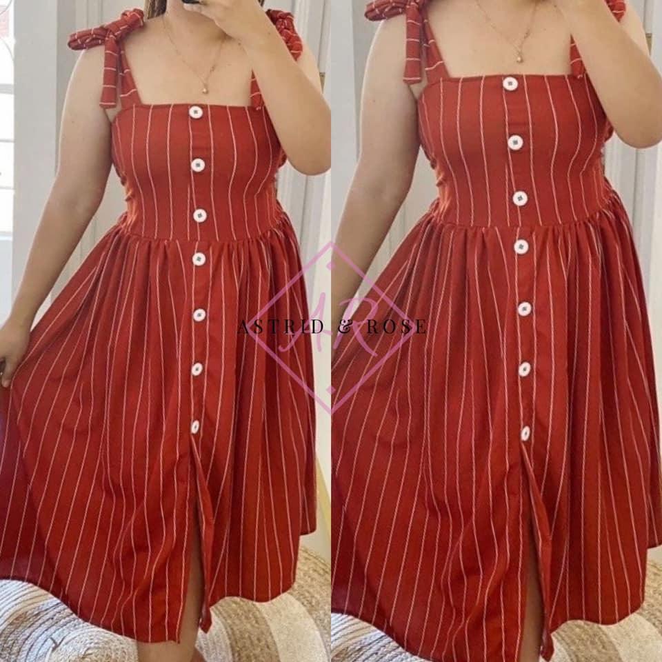 Plus size rust striped dress with button front and tie shoulder straps, modeled indoors