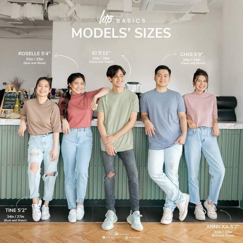 Group of five diverse models in casual premium tees and jeans standing indoors, smiling.