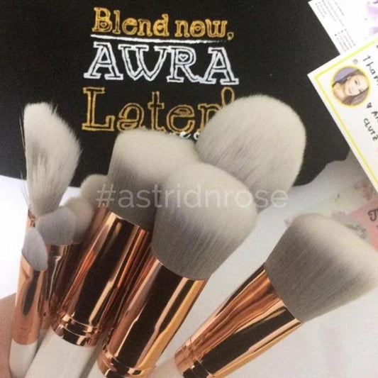 Set of soft makeup brushes with rose gold handles, ideal for beginners, on a styled background.