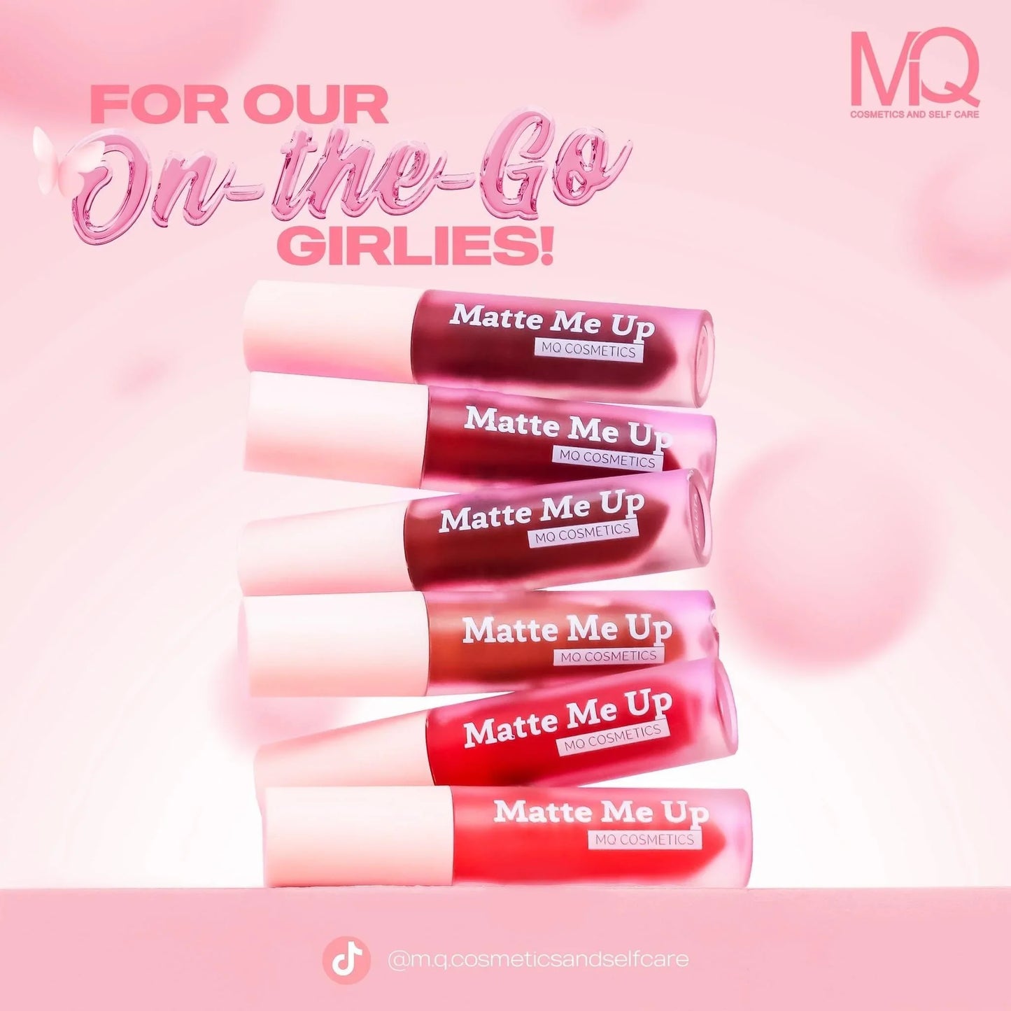 Matte Me Up MO Cosmetics lipsticks in various pink and red shades stacked on pink background